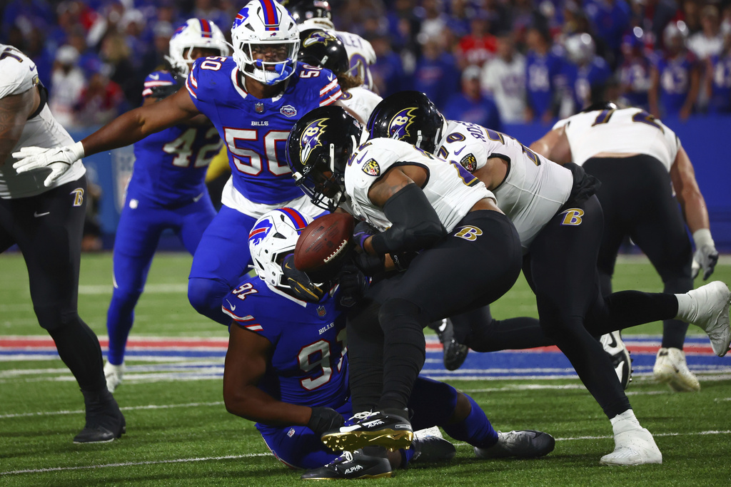Baltimore Ravens running back Derrick Henry (22) fumble the ball as he is hit by Buffalo Bills defensive tackle Ed Oliver (91) during the second half of an NFL football game in Orchard Park, N.Y., Sunday, Sept. 7, 2025. (AP Photo/Jeffrey T. Barnes)