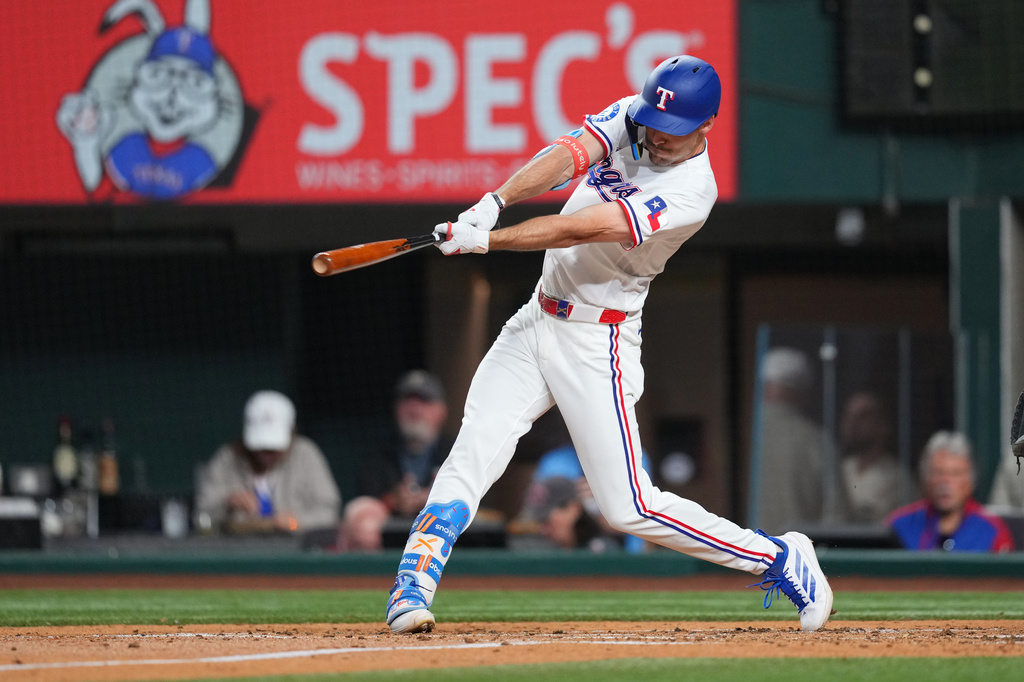 Texas Rangers' Evan Carter connects for an RBI single to score Joc Pederson from third base during the second inning of a baseball game against the Pittsburgh Pirates, Tuesday, April 21, 2026, in Arlington, Texas. (AP Photo/Julio Cortez)