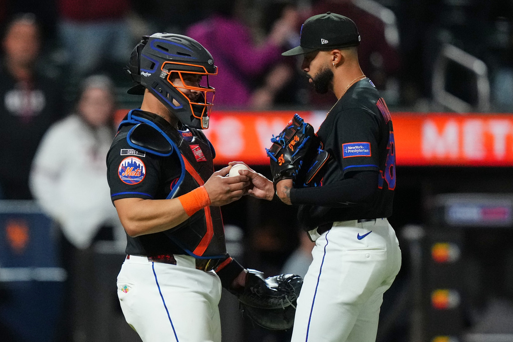 New York Mets catcher Francisco Alvarez, left, hands the ball to pitcher Devin Williams after a baseball game against the Minnesota Twins Thursday, April 23, 2026, in New York. (AP Photo/Frank Franklin II)