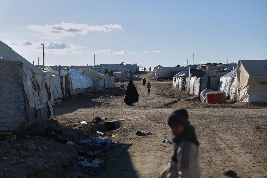 Residents walk along the al-Hol camp, one of the detention facilities holding thousands of Islamic State group members and their families, now under the control of the Syrian government following the withdrawal of the Syrian Democratic Forces (SDF), in al-Hassakeh province, northeastern Syria, Wednesday, Feb. 4, 2026. (AP Photo/Ghaith Alsayed)