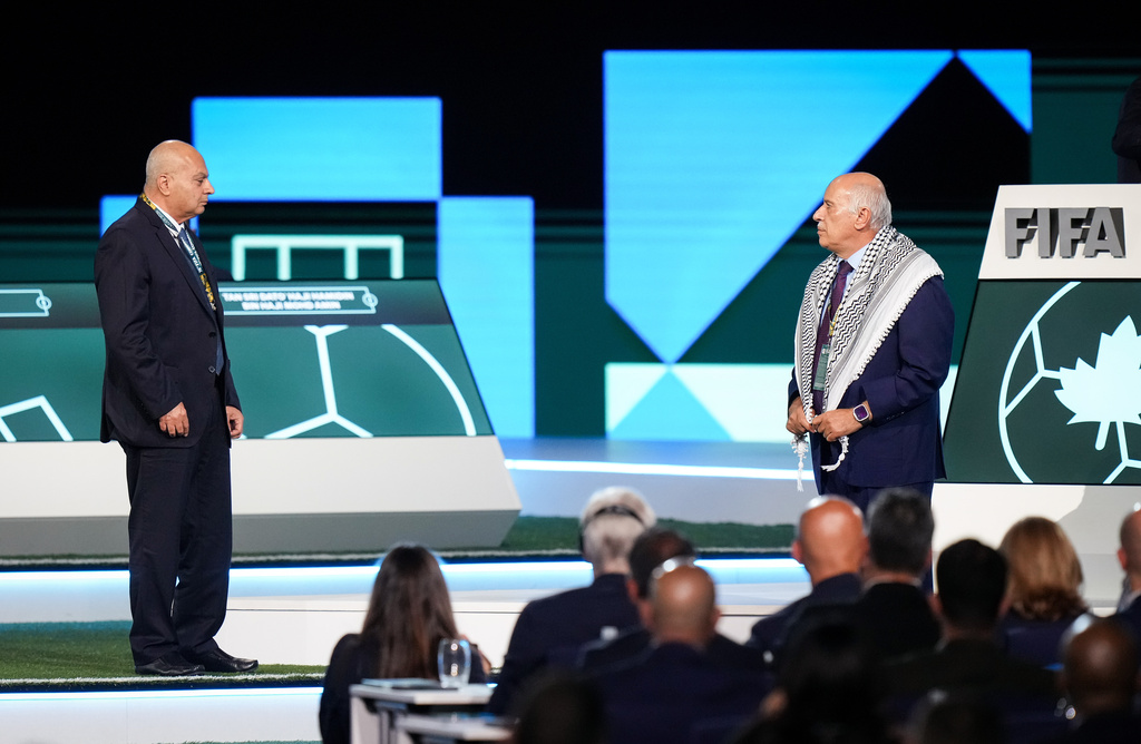 Palestinian Football Association President Jibril Rajoub, right, refuses to stand together with Israel Football Association Vice-President Basim Sheikh Suliman, left, after FIFA President Gianni Infantino, not seen, tried to bring them together during the 76th FIFA Congress in Vancouver, British Columbia, Thursday, April 30, 2026. (Darryl Dyck/The Canadian Press via AP)
