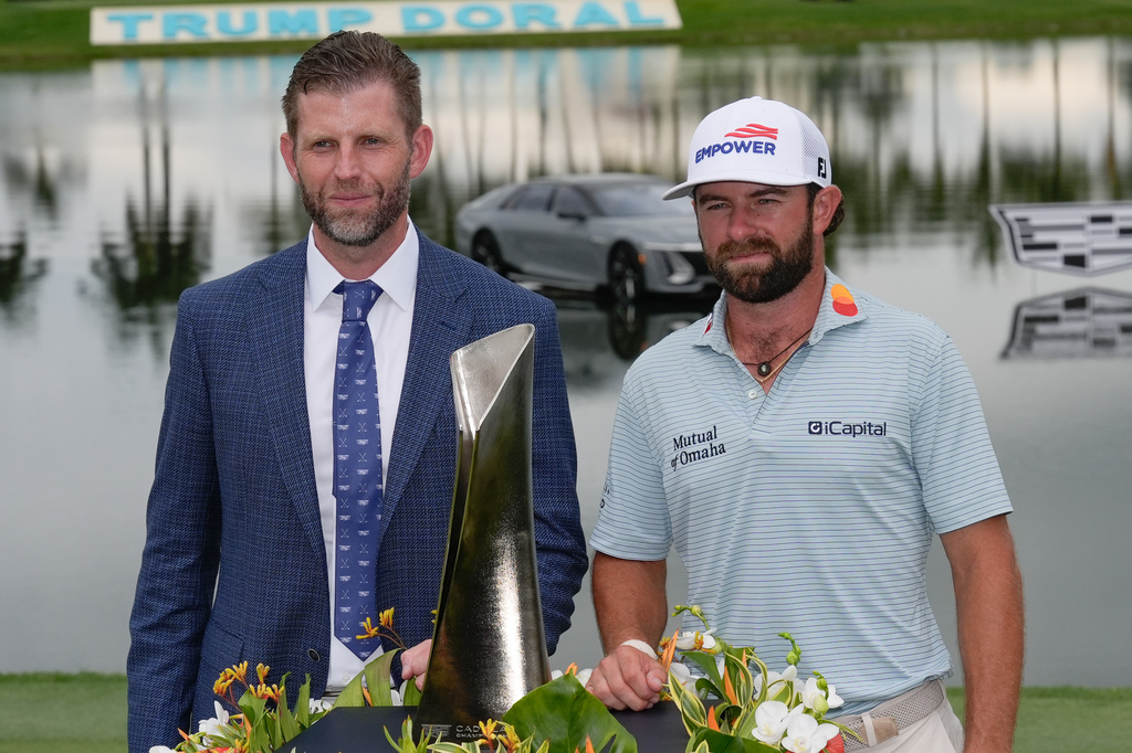 Cameron Young, right, stands with Eric Trump as he poses with the trophy after winning the Cadillac Championship PGA golf tournament Sunday, May 3, 2026, in Doral, Fla. (AP Photo/David J. Phillip)