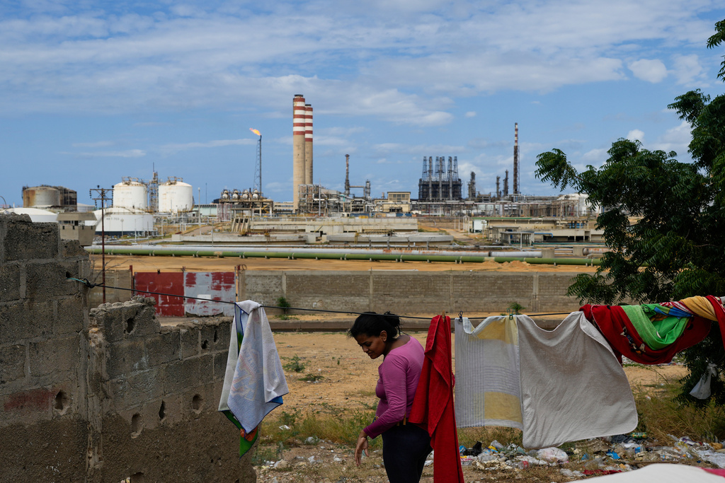 A woman who lives near the Cardon refinery hangs clothes to dry in Punto Fijo, Venezuela, Wednesday, Jan. 14, 2026. (AP Photo/Matias Delacroix)
