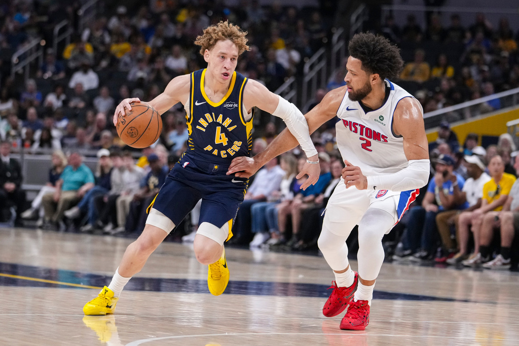 Indiana Pacers guard Taelon Peter (4) drives on Detroit Pistons guard Cade Cunningham (2) during the first half of an NBA basketball game in Indianapolis, Sunday, April 12, 2026. (AP Photo/Michael Conroy)