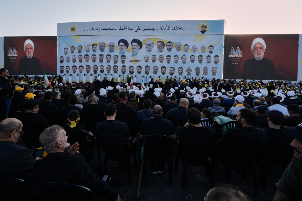 People listen as Hezbollah leader Naim Kassem delivers a televised speech during the first anniversary of the assassination of Hezbollah leader Sayyed Hassan Nasrallah, who was killed in Israeli airstrikes, at Nasrallah's grave in Beirut, Lebanon, Saturday, Sept. 27, 2025. (AP Photo/Bilal Hussein)