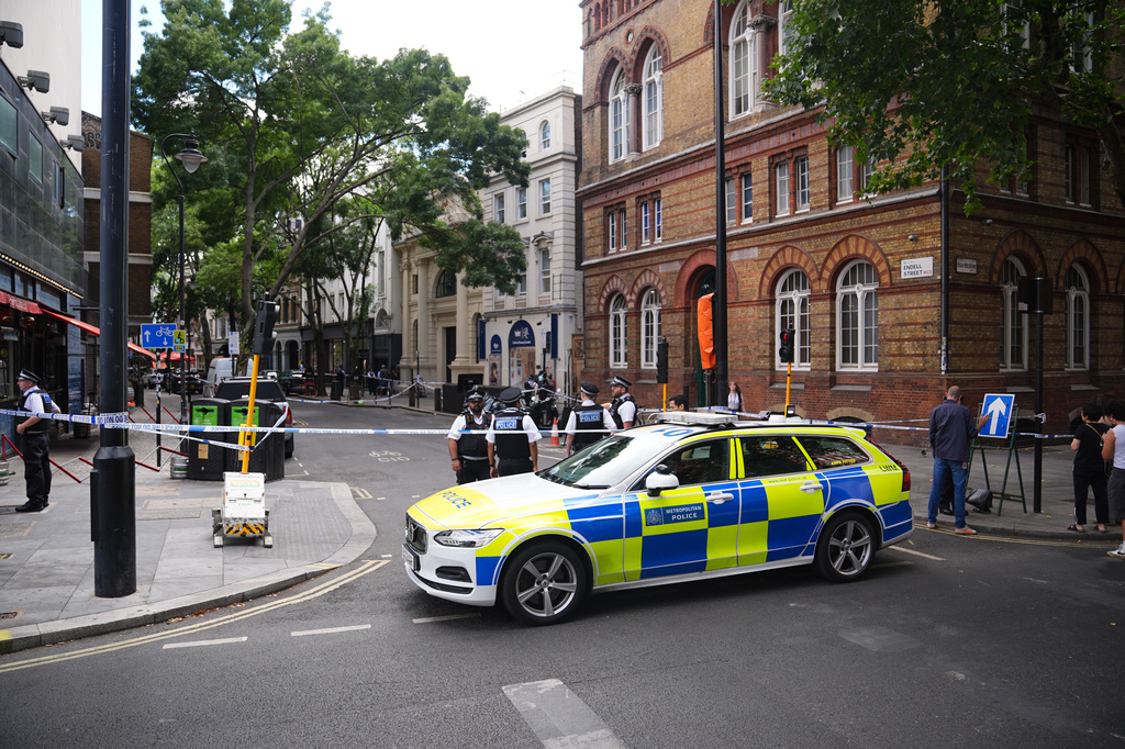 Police officers stand at the scene on Endell Street in Covent Garden, after four men were stabbed, in central London, Wednesday Aug. 5, 2026. PA Photo. (James Manning/PA via AP)