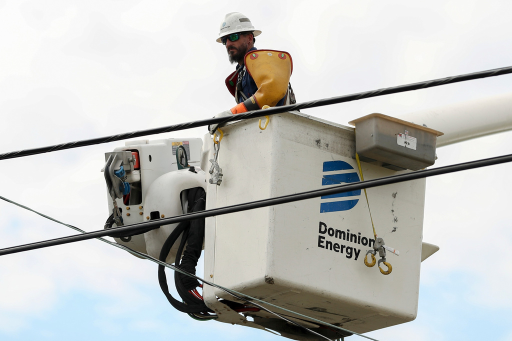 FILE - A Dominion Energy lineman lifts himself up to work on a power line in the aftermath of Hurricane Helene Sunday, Sept. 29, 2024, in North Augusta, S.C. (AP Photo/Artie Walker Jr., File)