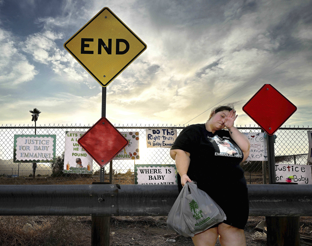 Arelene Sanchez-Turner, from Banning, wipes her eyes at a makeshift memorial prior to a vigil for missing 7-month-old Emmanuel Haro, outside the child's home in Cabazon, Calif. on Friday, Aug. 22, 2025. (Will Lester/The Orange County Register via AP)