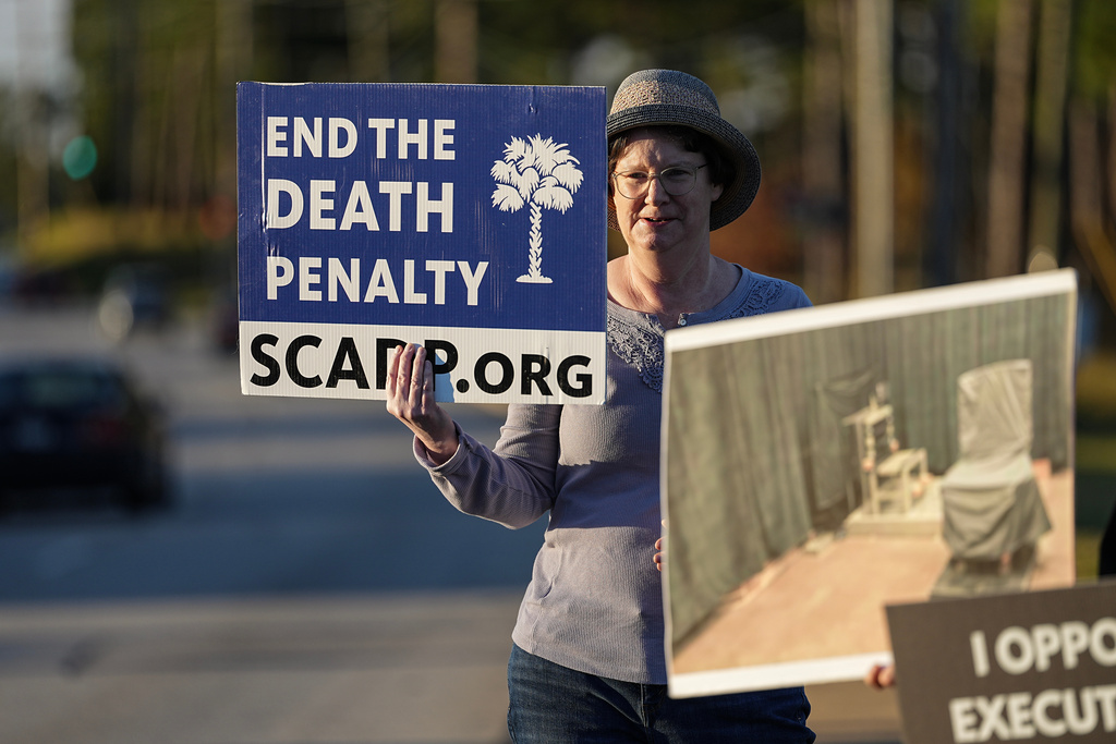 A protester holds signs outside of Broad River Correctional Institute prior to the scheduled execution of Stephen Bryant in Columbia, S.C., Friday, Nov. 14, 2025. (AP Photo/Matt Kelley)
