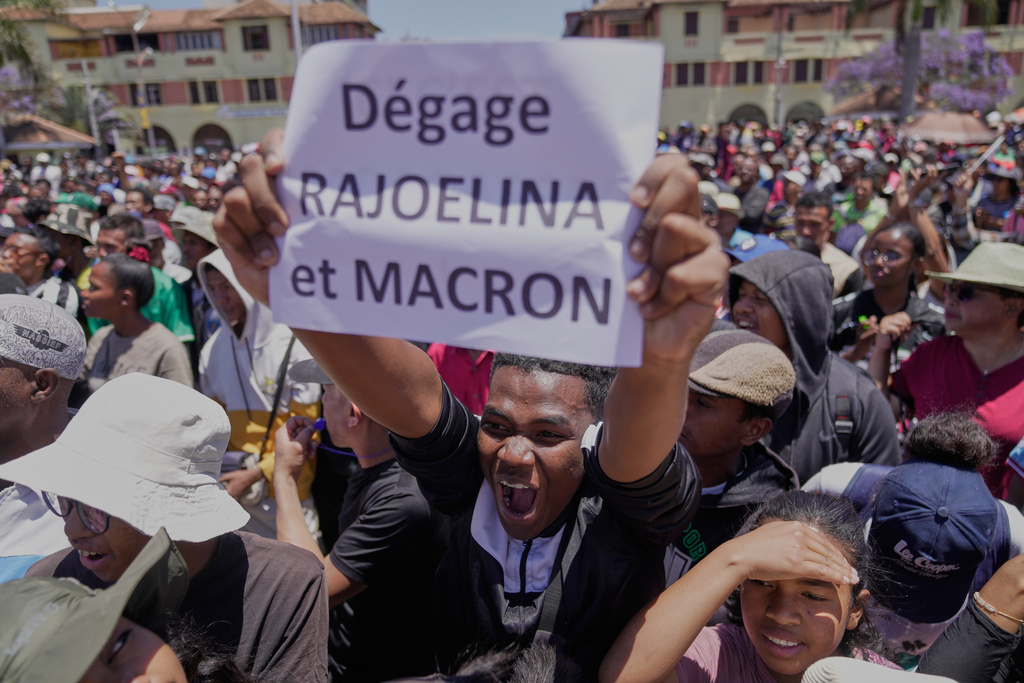 A protester displays a placard during a protest calling for President Andry Rajoelina to step down in Antananarivo, Madagascar, Tuesday, Oct. 14, 2025. (AP Photo/Brian Inganga)