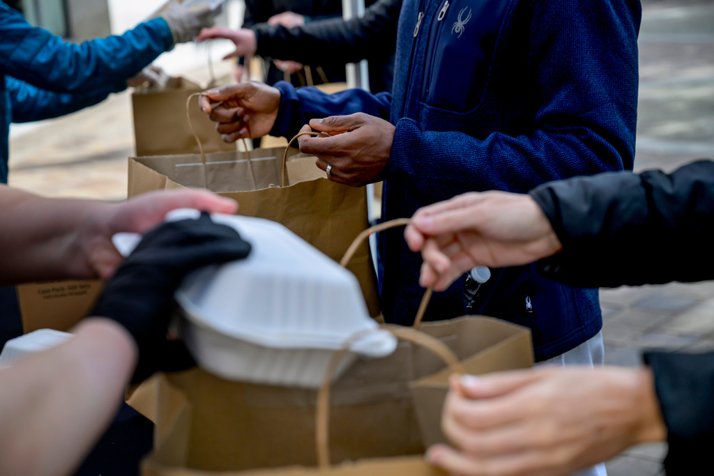 People receive free meals from the World Central Kitchen as they provide food to federal employees and their families near the U.S. Navy Memorial Plaza, during the federal government shutdown, Wednesday, Nov. 5, 2025, in Washington. (AP Photo/Rod Lamkey, Jr.)