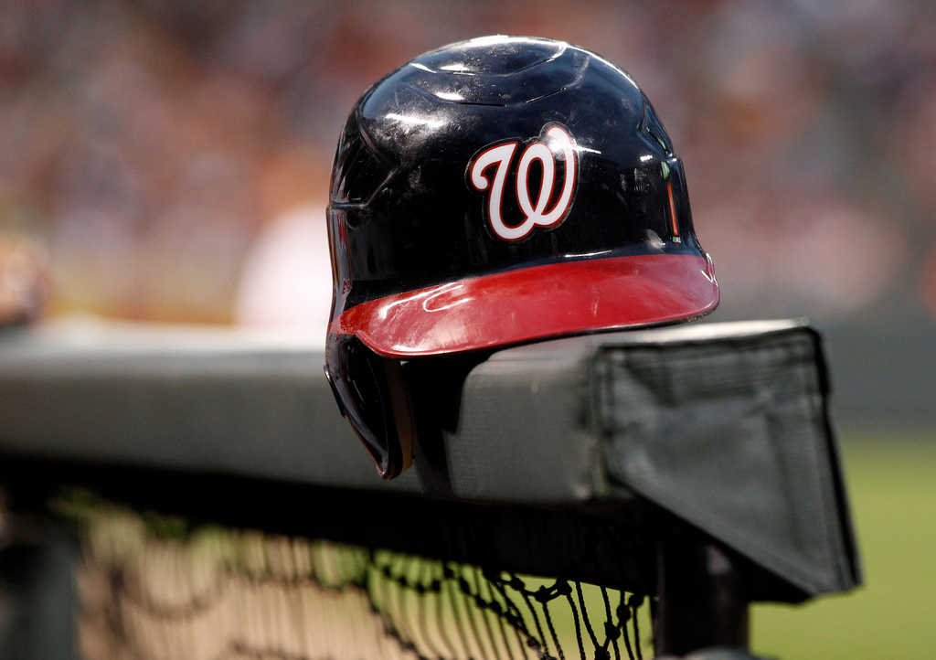 FILE - A Washington Nationals helmet sits in the dugout railing before a baseball game against the Baltimore Orioles in Baltimore, June 22, 2012. (AP Photo/Patrick Semansky, File)