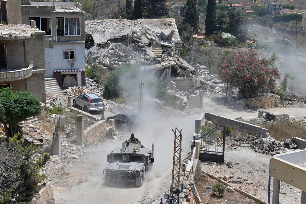 A Lebanese military vehicle drives past homes damaged during the war in the southern village of Zawtar al-Gharbieh, Lebanon, Monday, July 27, 2026. (AP Photo/Mustafa Jamalddine)