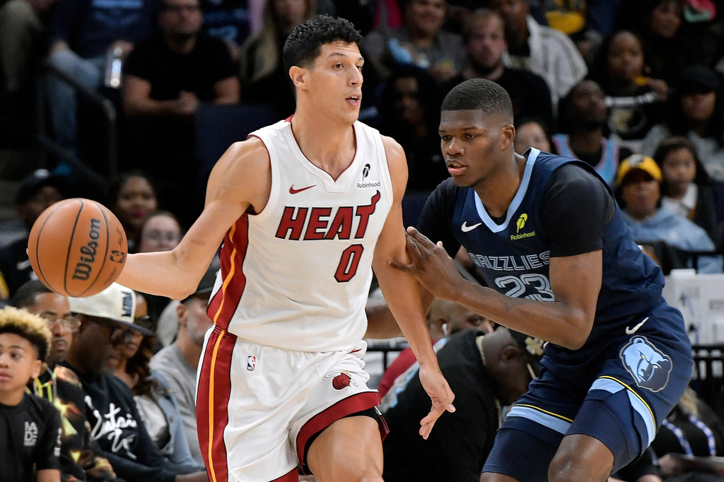 Miami Heat forward Simone Fontecchio (0) handles the ball against Memphis Grizzlies forward Cedric Coward (23) in the first half of an NBA basketball game Friday, Oct. 24, 2025, in Memphis, Tenn. (AP Photo/Brandon Dill)