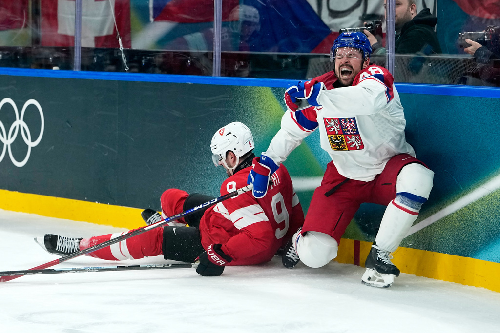 Czechia's Tomas Hertl (48) is challenged by Switzerland's Damien Riat (9) during a preliminary round match of men's ice hockey between Switzerland and Czechia at the 2026 Winter Olympics, in Milan, Italy, Sunday, Feb. 15, 2026. (AP Photo/Petr David Josek)
