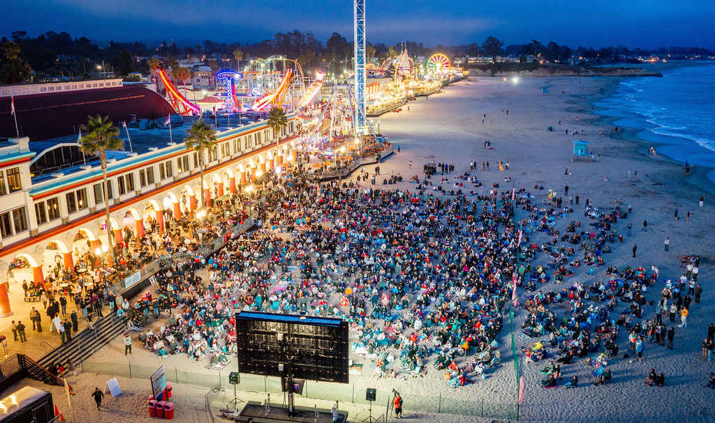 Fans watch a broadcast of the World Cup Group D soccer match between the United States and Turkey at the beach boardwalk in Santa Cruz, Calif., Thursday, June 25, 2026, (AP Photo/Noah Berger)