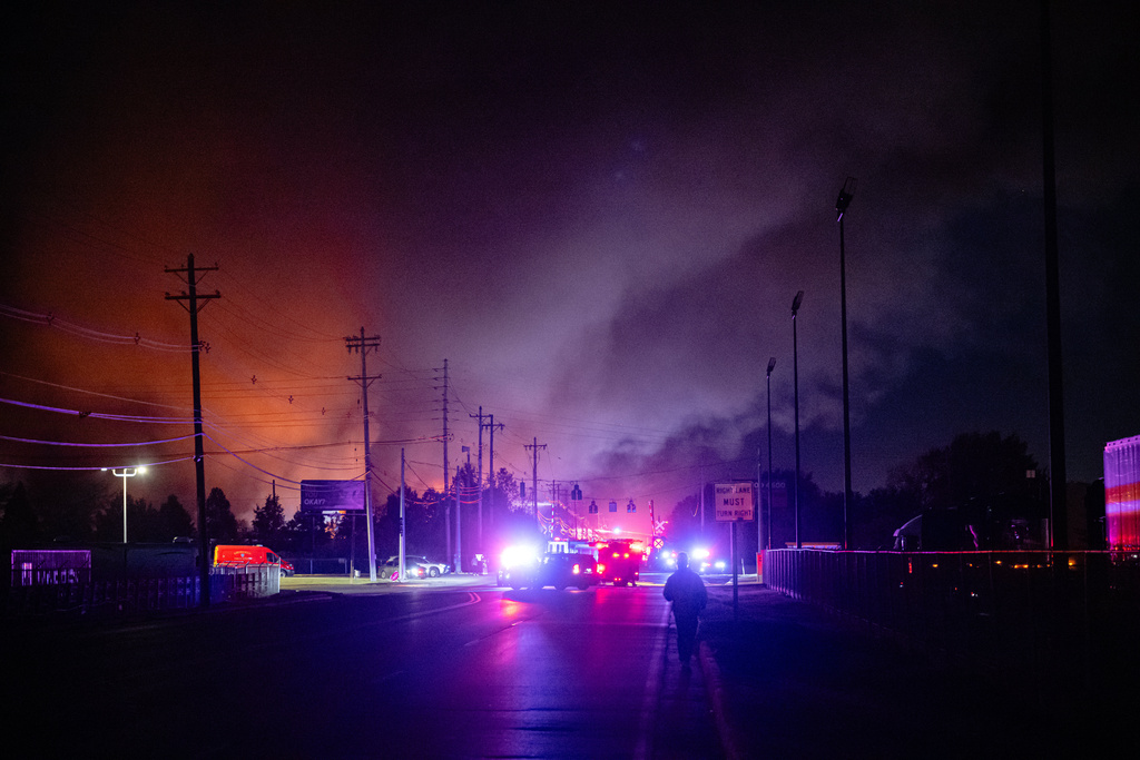 An employee walks to his workplace, the location of the reported crash, after a UPS cargo plane crashed and exploded while taking off at Louisville Muhammad Ali International Airport, Tuesday, Nov. 4, 2025, in Louisville, Ky. (AP Photo/Jon Cherry)