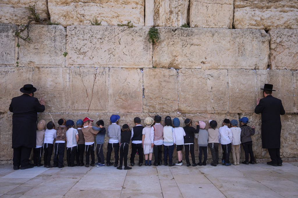 Ultra-Orthodox Jewish men and children pray at the Western Wall, the holiest site where Jews can pray, in the Old City of Jerusalem, Sunday, April 19, 2026. (AP Photo/Ohad Zwigenberg)