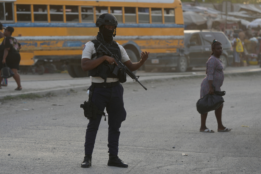 Police officers patrol an intersection in Port-au-Prince, Haiti, Tuesday, Sept. 30, 2025. (AP Photo/Odelyn Joseph)