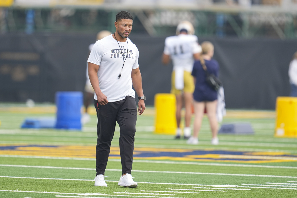 FILE - Notre Dame head coach Marcus Freeman walks between drills during NCAA college football practice in South Bend, Ind., July 31, 2025. (AP Photo/Michael Conroy, file)