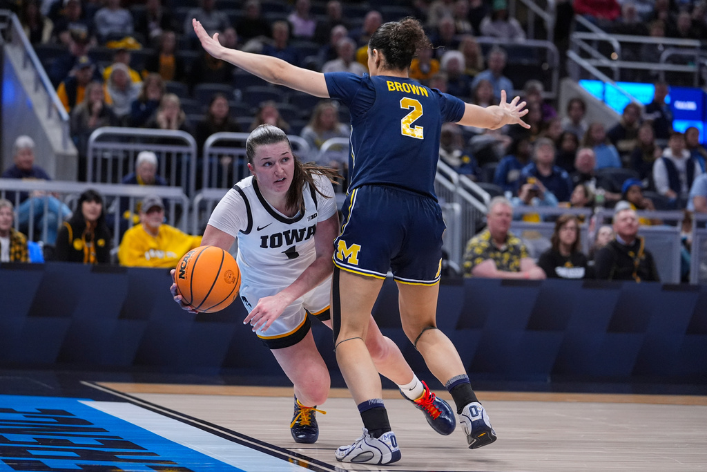 Iowa guard Taylor Stremlow (1) makes a pass around Michigan guard Macy Brown (2) in the second half of an NCAA college basketball game in the semifinals of the Big Ten Conference tournament, Saturday, March 7, 2026 in Indianapolis. (AP Photo/Michael Conroy)