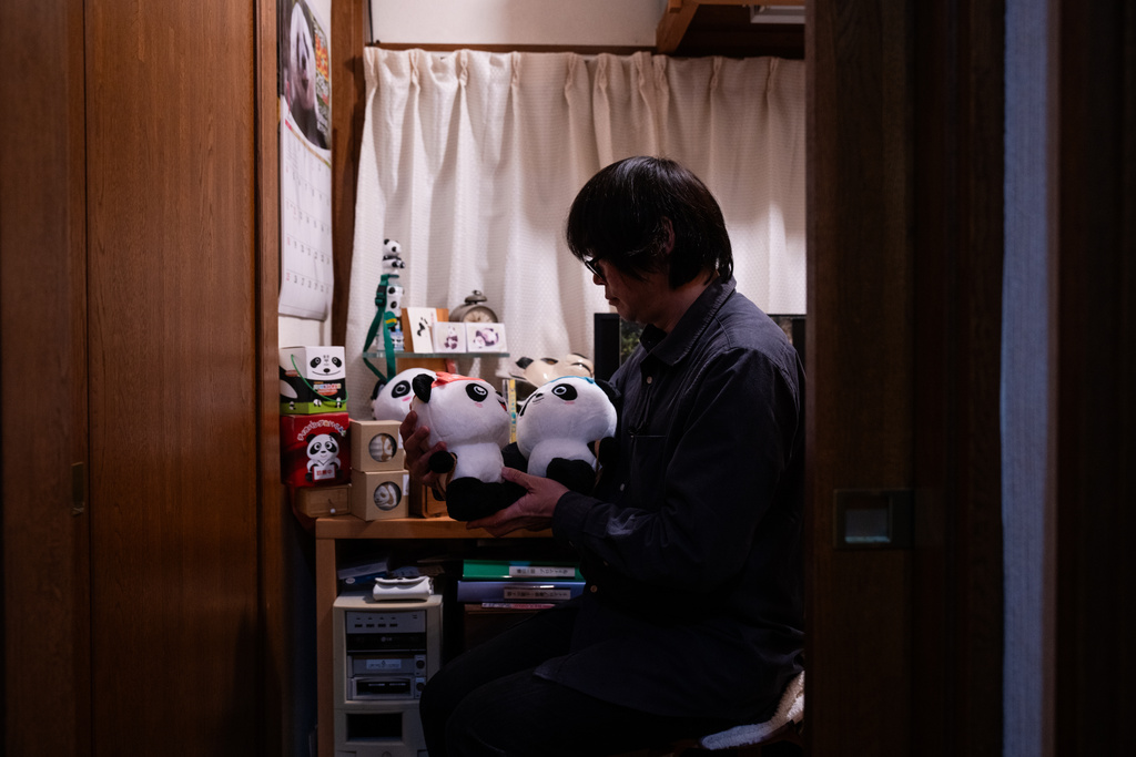 Takahiro Takauji holds panda plush toys during an interview at his home in Saitama, Monday, Jan. 19, 2026. (AP Photo/Louise Delmotte)