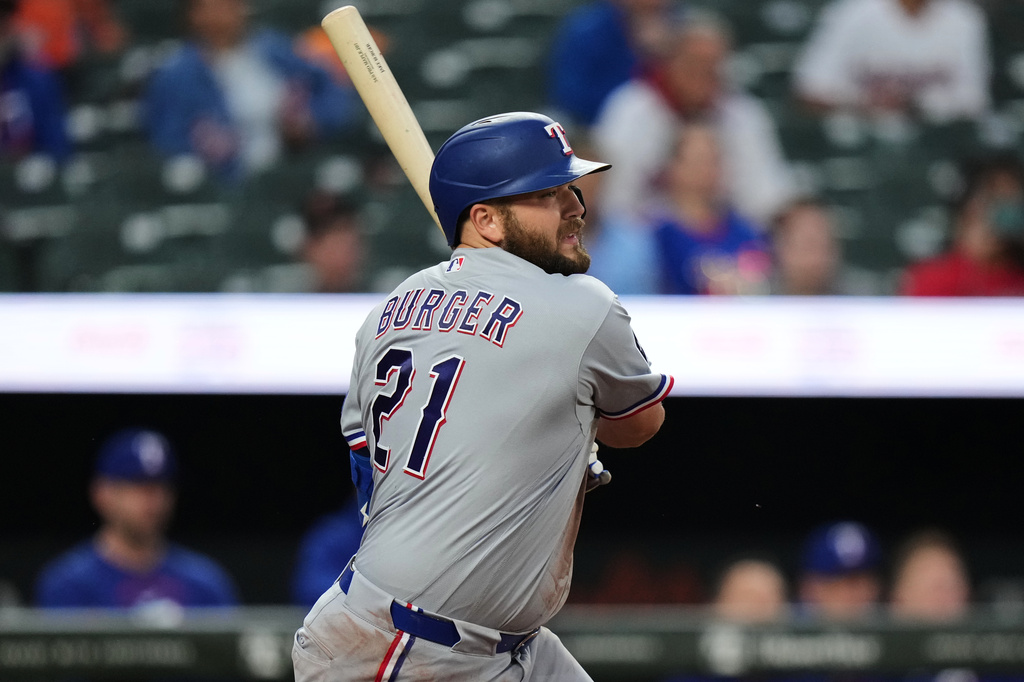 Texas Rangers' Jake Burger (21) follows through on an RBI single during the second inning of a baseball game against the Baltimore Orioles, Monday, March 30, 2026, in Baltimore. (AP Photo/Stephanie Scarbrough)