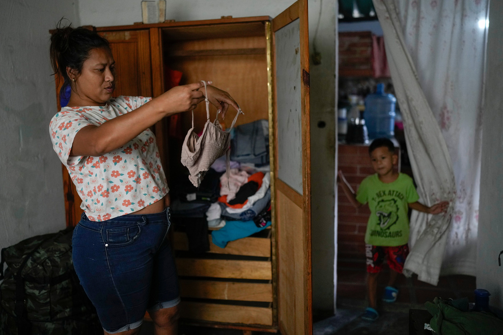 Mariela Gómez, a Venezuelan migrant who gave up her journey with her children to the United States following the immigration crackdown under President Donald Trump, chooses what to wear for a family Christmas dinner in Maracay, Venezuela, Friday, Dec. 24, 2025. (AP Photo/Matias Delacroix)