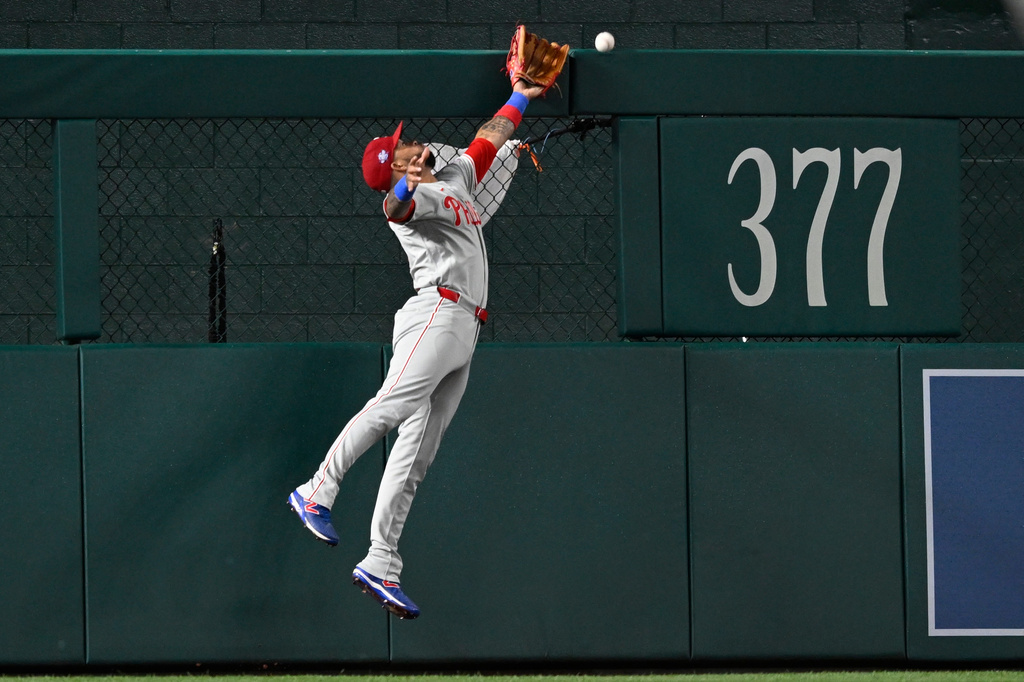 Philadelphia Phillies left fielder Edmundo Sosa cannot catch a double hit by Washington Nationals' Dylan Crews that bounces off the fence during the fifth inning of a baseball game, Monday, June 22, 2026, in Washington. (AP Photo/John McDonnell)
