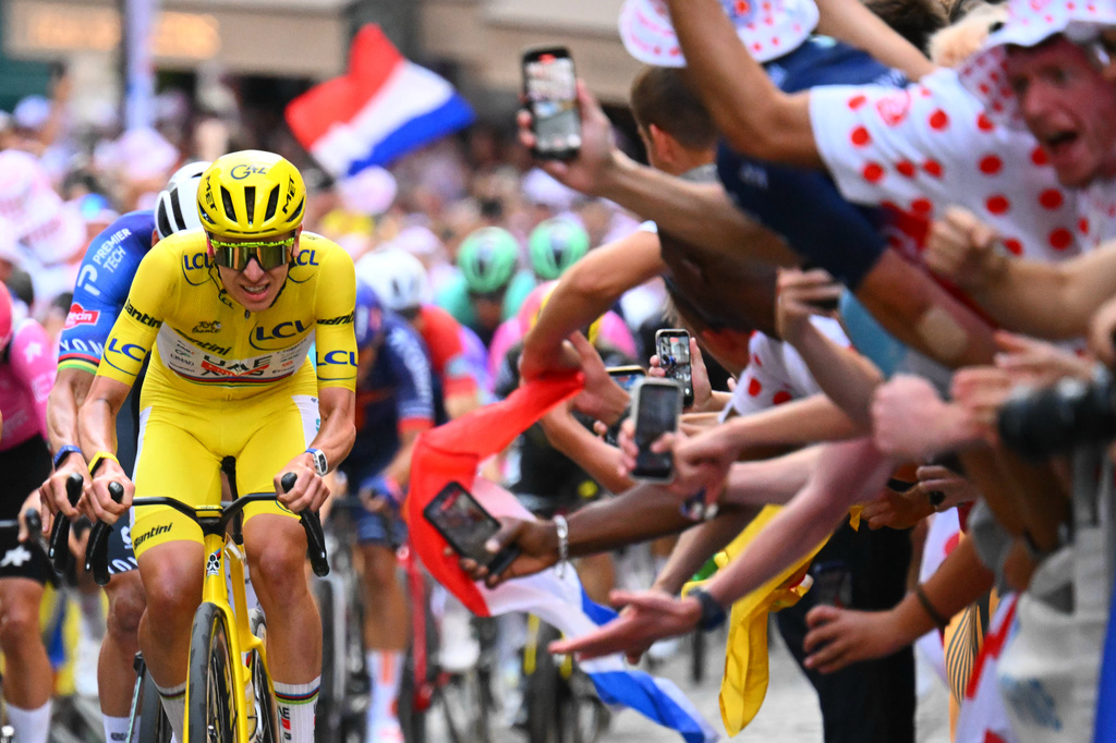 Slovenia's Tadej Pogacar, wearing the overall leader's yellow jersey, races through the cobbled streets of Montmartre during the last stage of the Tour de France cycling race with start and finish in Paris, Sunday, July 26, 2026. (AP Photo/Etienne Garnier/Pool Photo via AP)