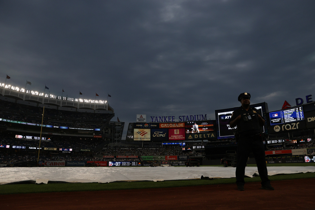 A police officer stands by as a baseball game between the New York Yankees and Boston Red Sox is delayed due to weather, Saturday, June 6, 2026, in New York. (AP Photo/Heather Khalifa)