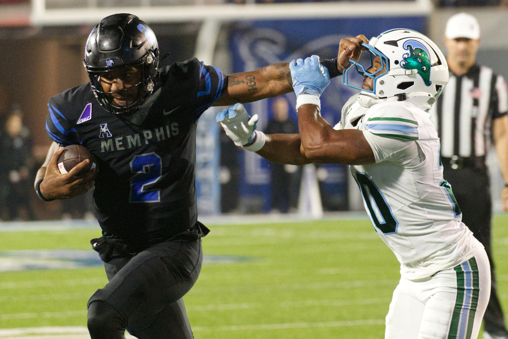 Memphis quarterback Brendon Lewis (2) carries the football defended by Tulane defensive back Jahiem Johnson, right, during the second half of an NCAA college football game, Friday, Nov. 7, 2025, in Memphis, Tenn. (AP Photo/Nikki Boertman)