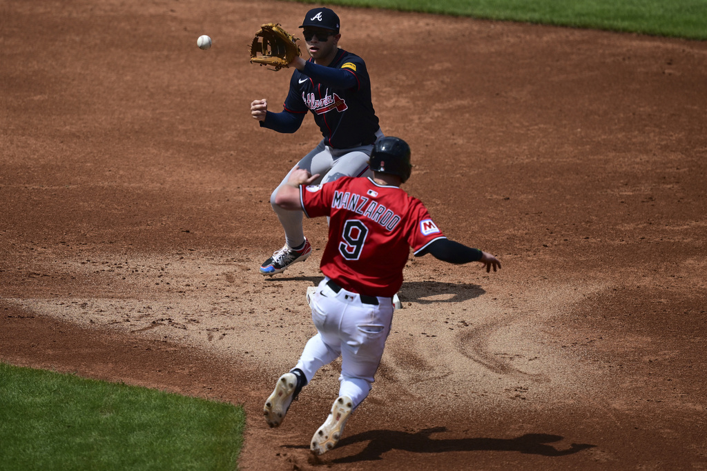 Atlanta Braves shortstop Nick Allen, top, forces out Cleveland Guardians' Kyle Manzardo (9) at second base during the second inning of a baseball game, Sunday, Aug. 17, 2025, in Cleveland. (AP Photo/David Dermer)