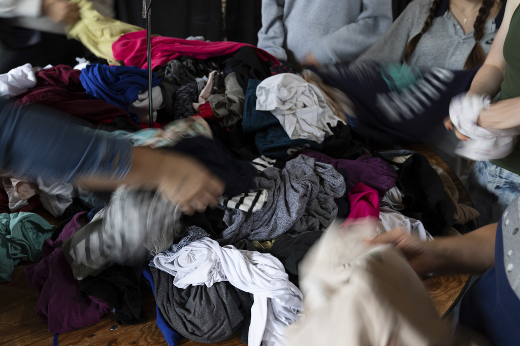 Attendees look at items during a clothing swap on Sunday, Sept. 14, 2025, in Portland, Ore. (AP Photo/Jenny Kane)