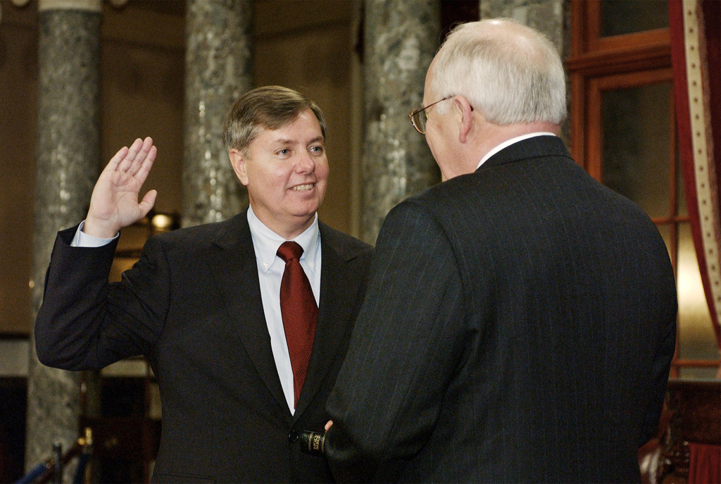 FILE - Sen. Lindsey Graham, R-S.C., takes the oath of office with Vice President Dick Cheney, right, during a re-enactment swearing-in ceremony in the Old Senate Chamber on Capitol Hill in Washington, Jan. 7, 2003, following his election to the Senate. (AP Photos/Evan Vucci, File)