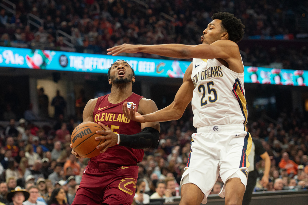 Cleveland Cavaliers' Donovan Mitchell, left, drives against New Orleans Pelicans' Trey Murphy III (25) during the first half of an NBA basketball game in Cleveland, Tuesday, Dec. 23, 2025. (AP Photo/Phil Long)