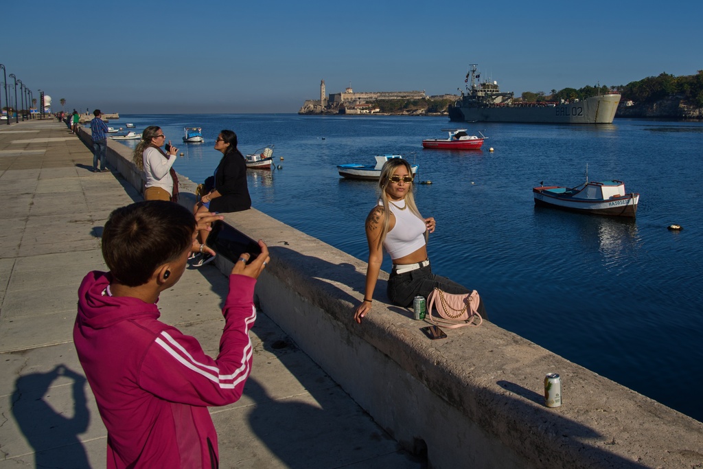 People take photos at Havana Bay as the Mexican Navy ship Isla Holbox, carrying aid according to the Mexican government, arrives in Cuba, Thursday, Feb. 12, 2026. (AP Photo/Ramon Espinosa)