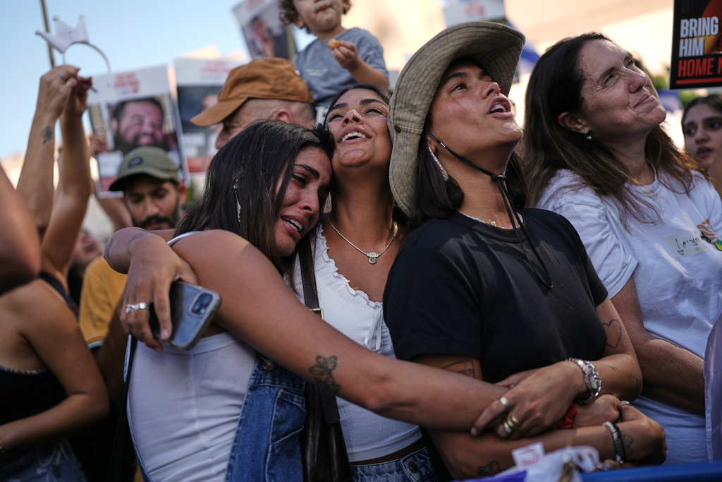 People react as they gather to watch a live broadcast of Israeli hostages released from Gaza at a plaza known as hostages square in Tel Aviv, Israel, Monday, Oct. 13, 2025. The release took place as part of a cease-fire agreement between Israel and Hamas. (AP Photo/Oded Balilty)