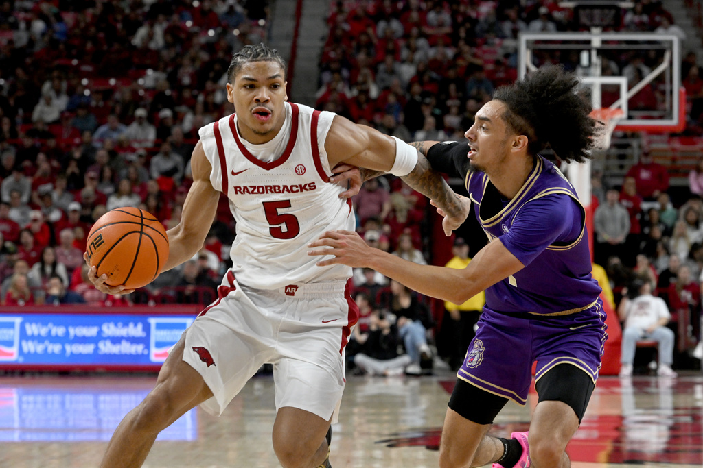 Arkansas guard Darius Acuff Jr. (5) tries to drive past James Madison guard Paul Jones III (1) during an NCAA college basketball game Monday, Dec. 29, 2025, in Fayetteville, Ark. (AP Photo/Michael Woods)