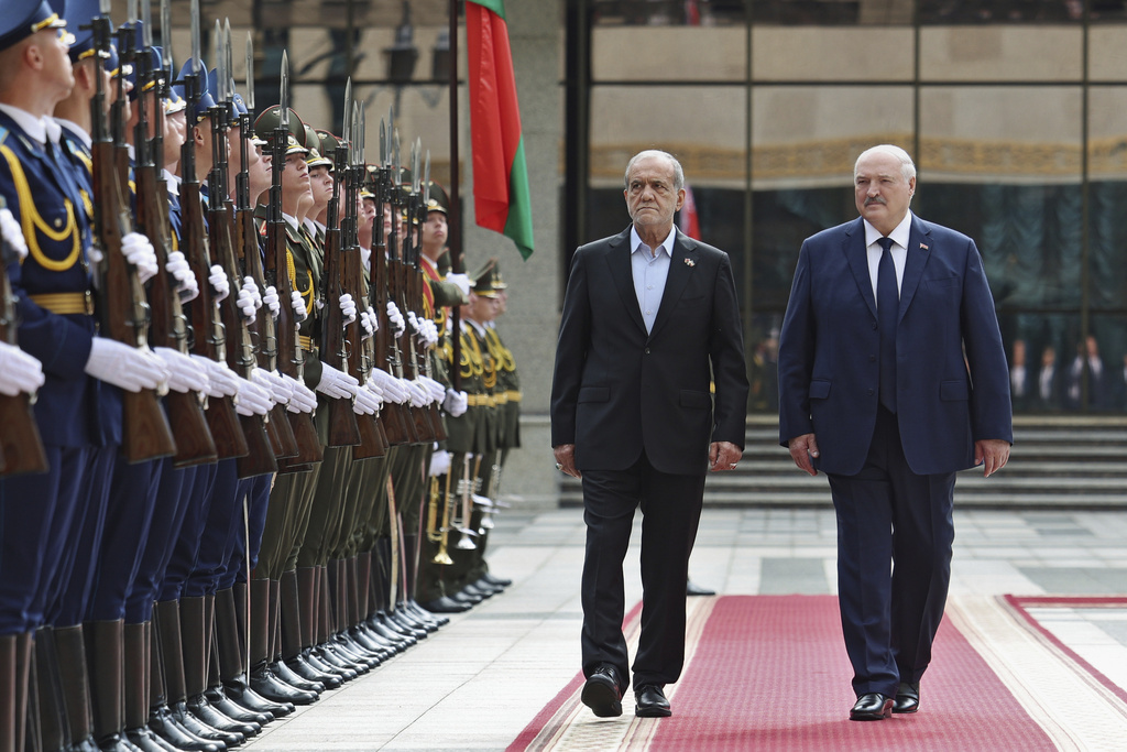 In this photo, released by Belarusian Presidential Press Service, Belarusian President Alexander Lukashenko, right, and Iranian President Masoud Pezeshkian attend a welcome ceremony prior to their talks in Minsk, Belarus, Wednesday, Aug. 20, 2025. (Belarusian Presidential Press Service via AP)