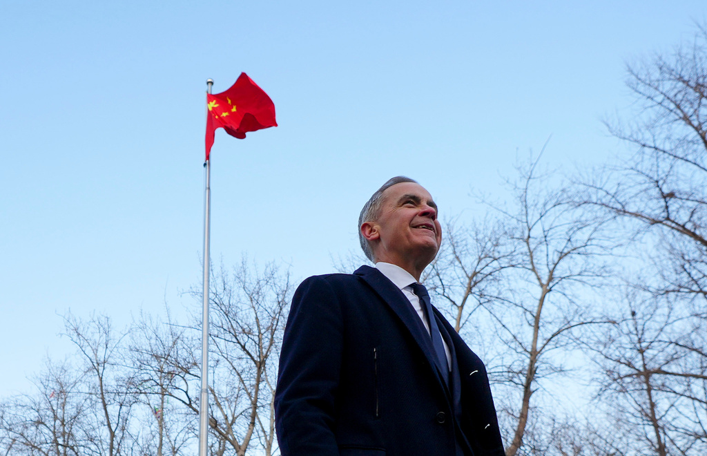Prime Minister Mark Carney walks past a Chinese flag as he leaves after holding a press conference in Ritan Park in Beijing, China on Friday, Jan. 16, 2026. (Sean Kilpatrick /The Canadian Press via AP)