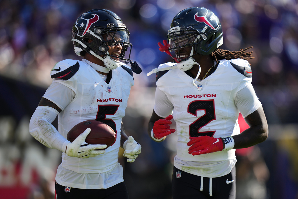 Houston Texans safety Jalen Pitre celebrates with safety Calen Bullock (2) after an interception during the second half of an NFL football game against the Baltimore Ravens, Sunday, Oct. 5, 2025, in Baltimore. (AP Photo/Stephanie Scarbrough)