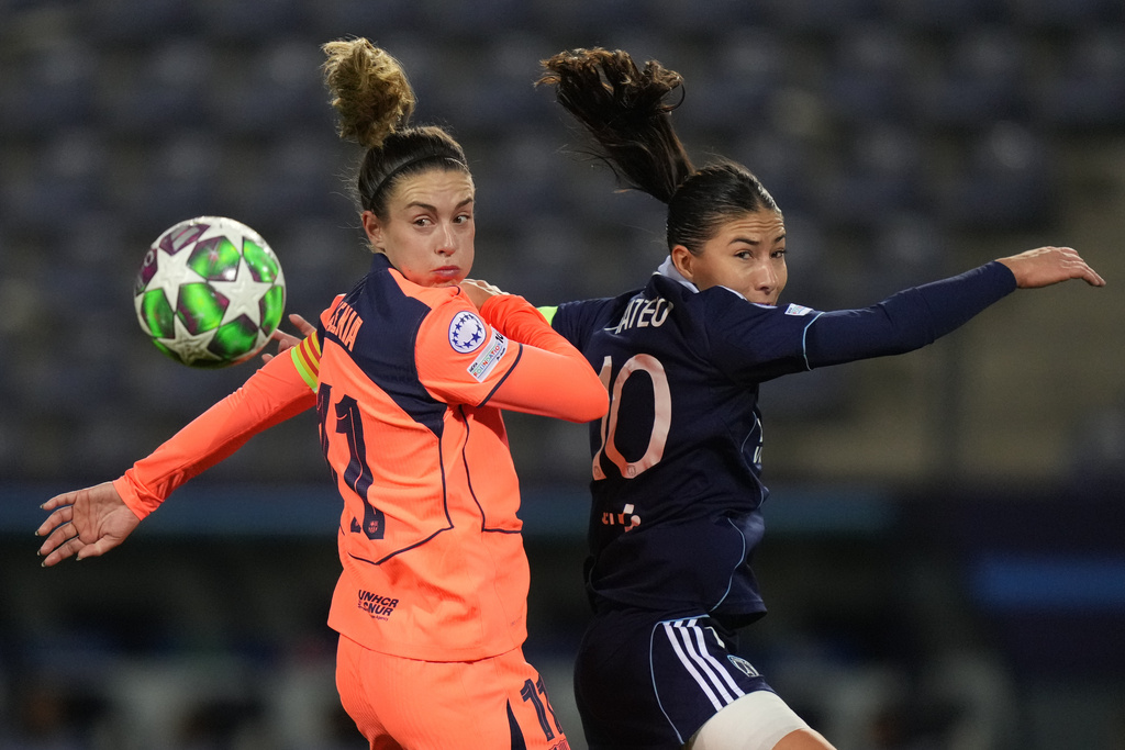 Barcelona's Alexia Putellas, left, and vClara Mateo jump for the ball during a Women's Champions League soccer match between Paris FC and Barcelona in Paris, Wednesday, Dec. 17, 2025. (AP Photo/Thibault Camus)
