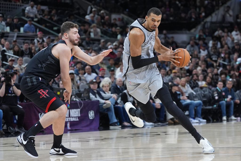 San Antonio Spurs forward Victor Wembanyama (1) drives around Houston Rockets center Alperen Sengun (28) during the first half of an NBA basketball game in San Antonio, Sunday, March 8, 2026. (AP Photo/Eric Gay)
