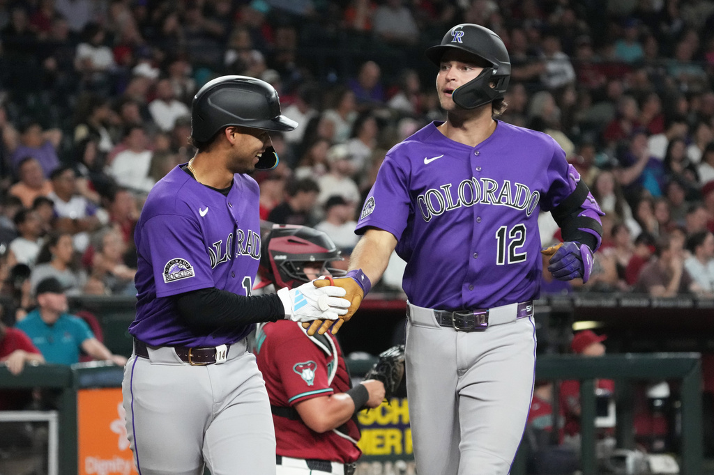 Colorado Rockies' Kyle Karros (12) celebrates with Ezequiel Tovar after hitting a two-run home run against the Arizona Diamondbacks in the first inning of a baseball game, Tuesday, Aug 11, 2026, in Phoenix. (AP Photo/Rick Scuteri)