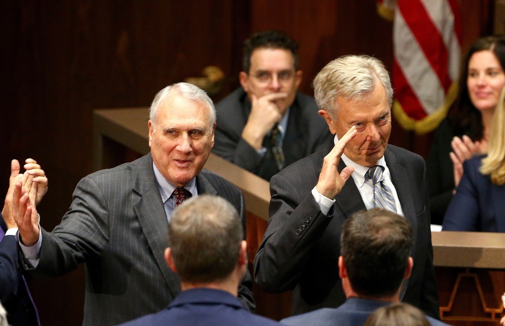 FILE - Former Arizona Republican Sen. Jon Kyl, left, and Bruce Babbitt, right, former Arizona Republican governor and secretary of the Interior, wave to the crowd as they are recognized during Arizona Gov. Doug Ducey's state of the state address Monday, Jan. 14, 2019, in Phoenix. (AP Photo/Ross D. Franklin,File)