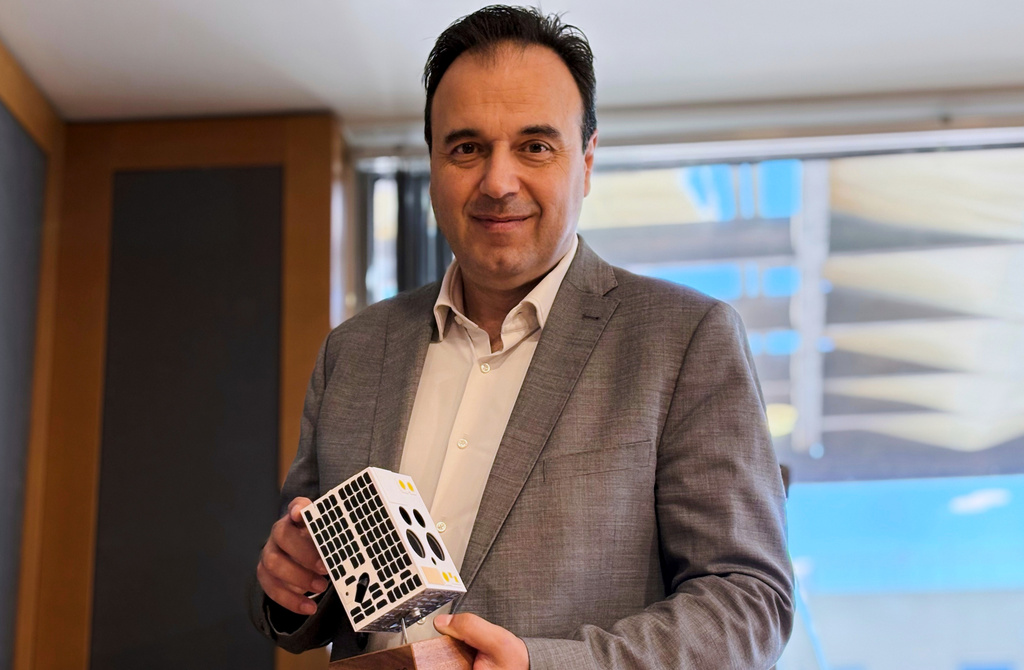 Digital Governance Minister Dimitris Papastergiou, poses with a mock-up of a nanosatellite in Athens, Greece, Tuesday, June 23, 2026. (AP Photo/Lefteris Pitarakis)