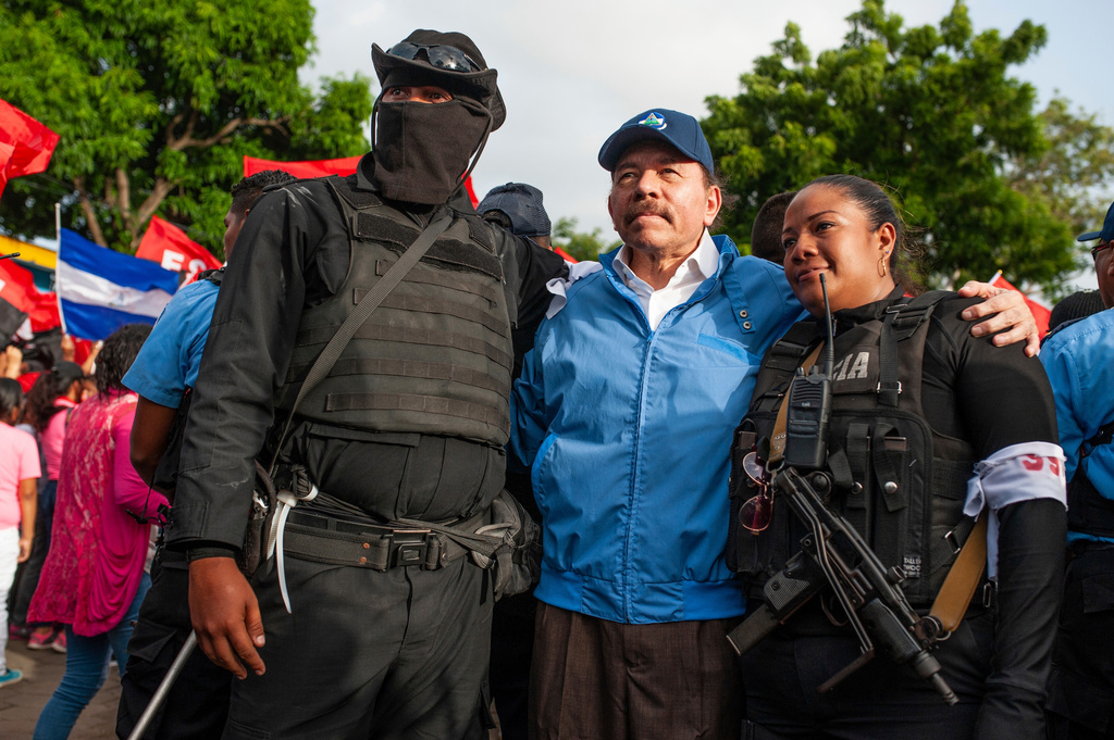 FILE - Nicaraguan police have their picture taken with President Daniel Ortega, in Masaya, Nicaragua, July 13, 2018. (AP Photo/Cristobal Venegas, File)