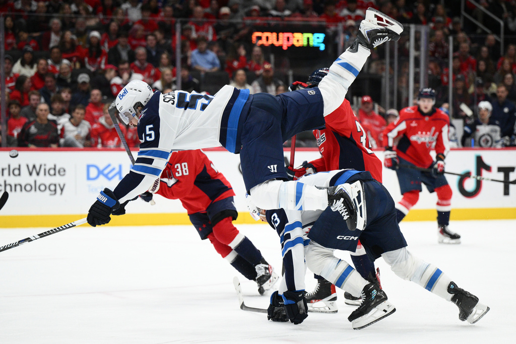 Winnipeg Jets center Mark Scheifele gets upended next to teammate center Gabriel Vilardi during the second period of an NHL hockey game against the Washington Capitals, Wednesday, Nov. 26, 2025, in Washington. (AP Photo/Nick Wass)
