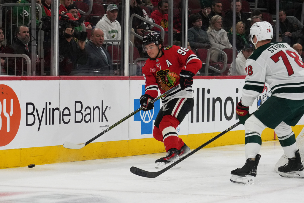 Chicago Blackhawks center Connor Bedard (98) and Minnesota Wild center Nico Sturm (78) go for the puck during the first period of an NHL hockey game Tuesday, March, 17, 2026, in Chicago. (AP Photo/David Banks)